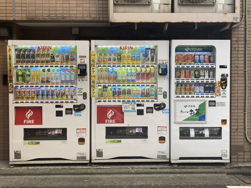 Three public vending machines next to each other on the side of the street.