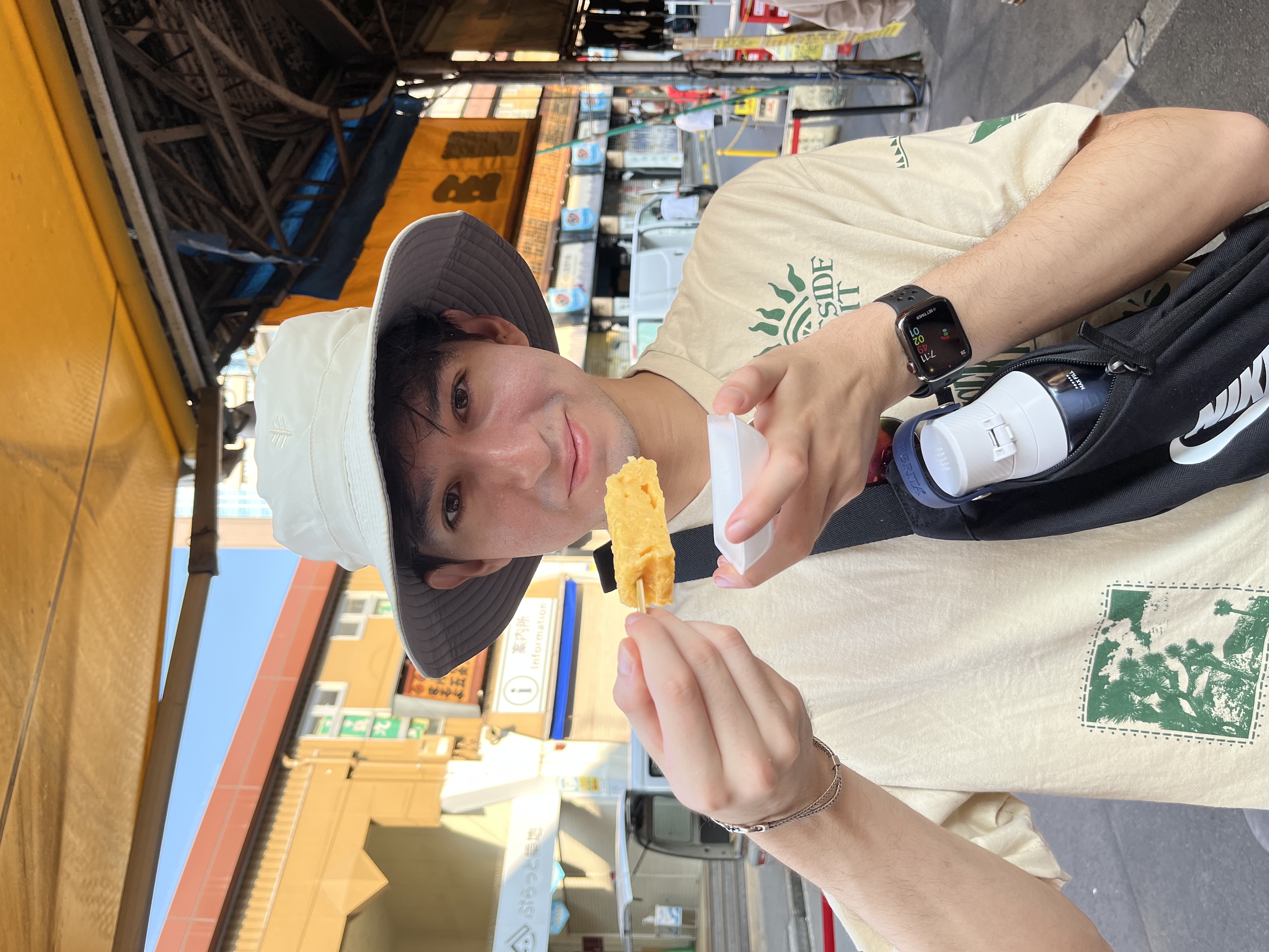 A picture of me holding an egg on a stick from Tamagoyaki Tsukiji Shoro.